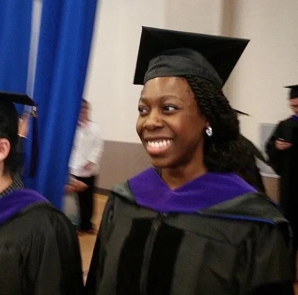 Dayo smiling in graduation robes